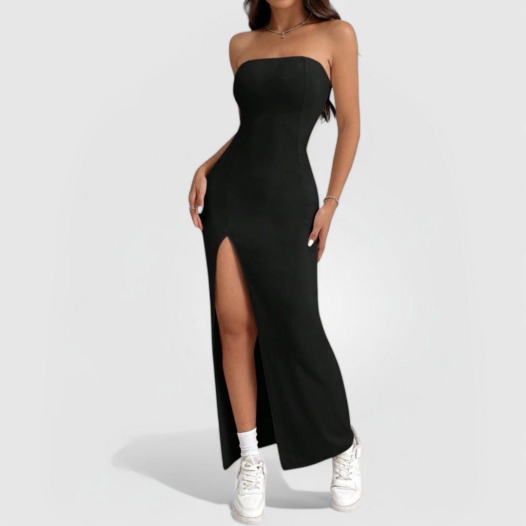 Woman wearing Strapless Slit Maxi – Black dress with thigh-high slit and white sneakers on light background.