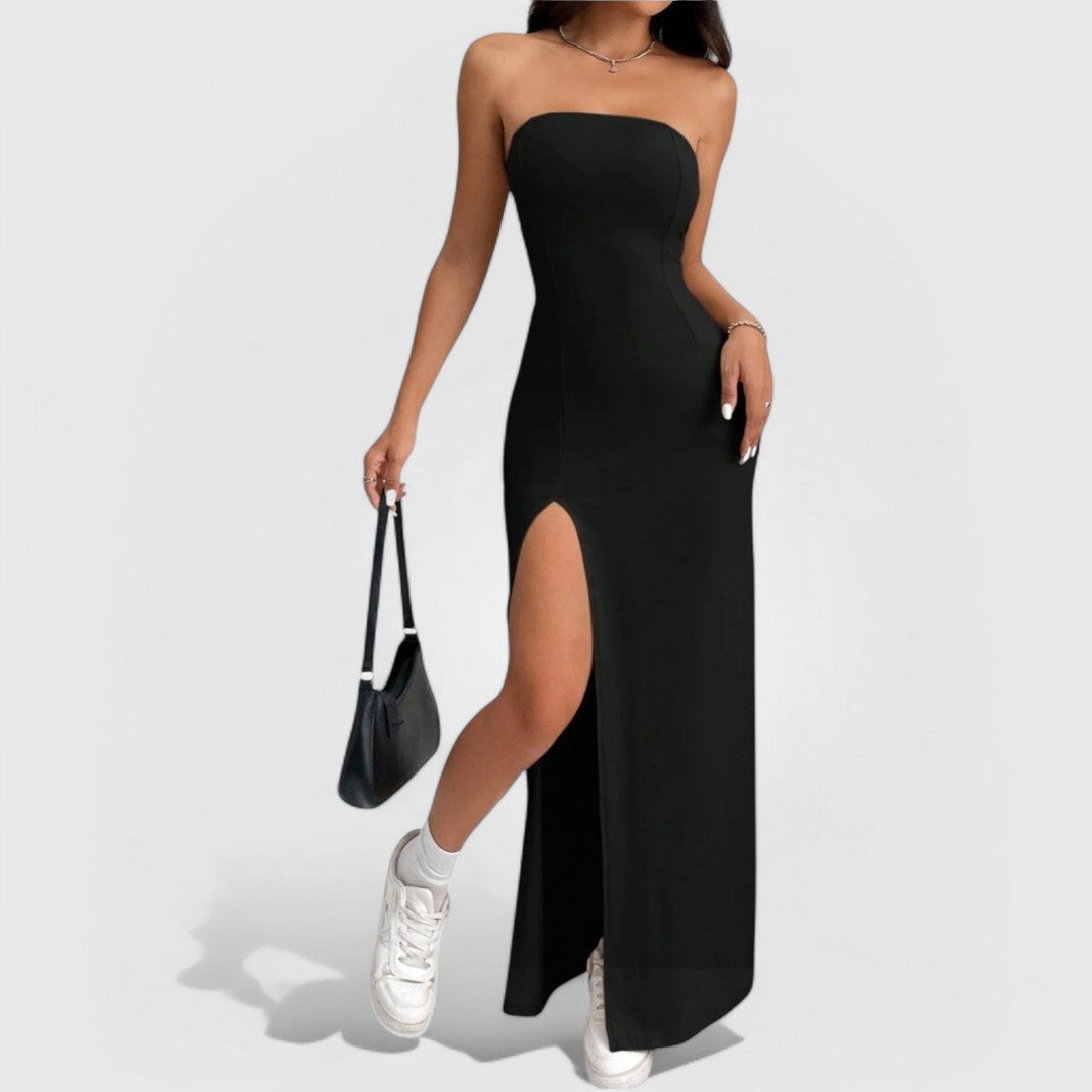 Model wearing Strapless Slit Maxi – Black dress with thigh-high slit, paired with sneakers and a handbag.