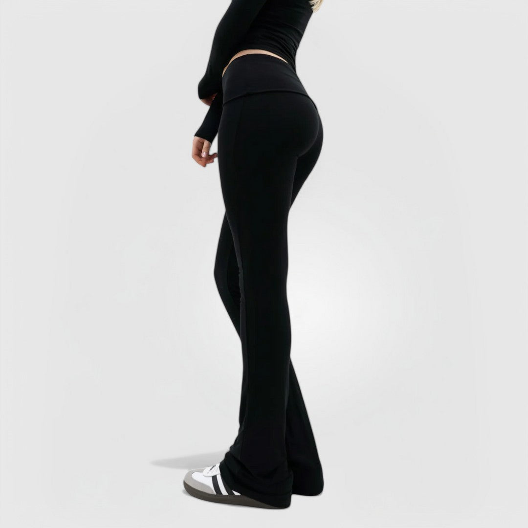 Woman wearing black CloudKnit™ Flare Leggings with high-rise waistband and ankle-length fit, standing sideways.