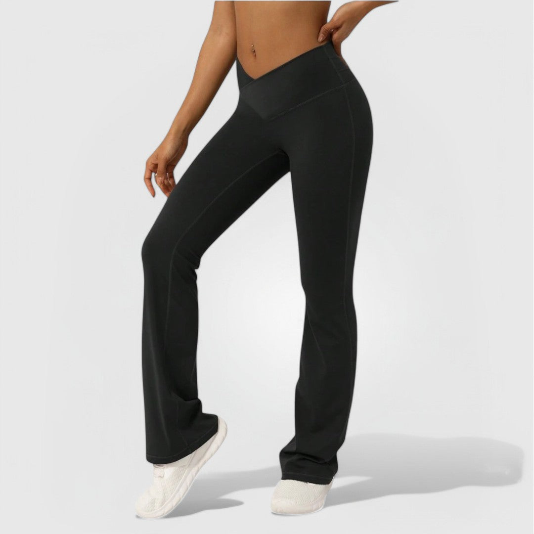 Black Everyday Flare Pants with a high-waisted fit and slight flare shown on a model standing in white sneakers.