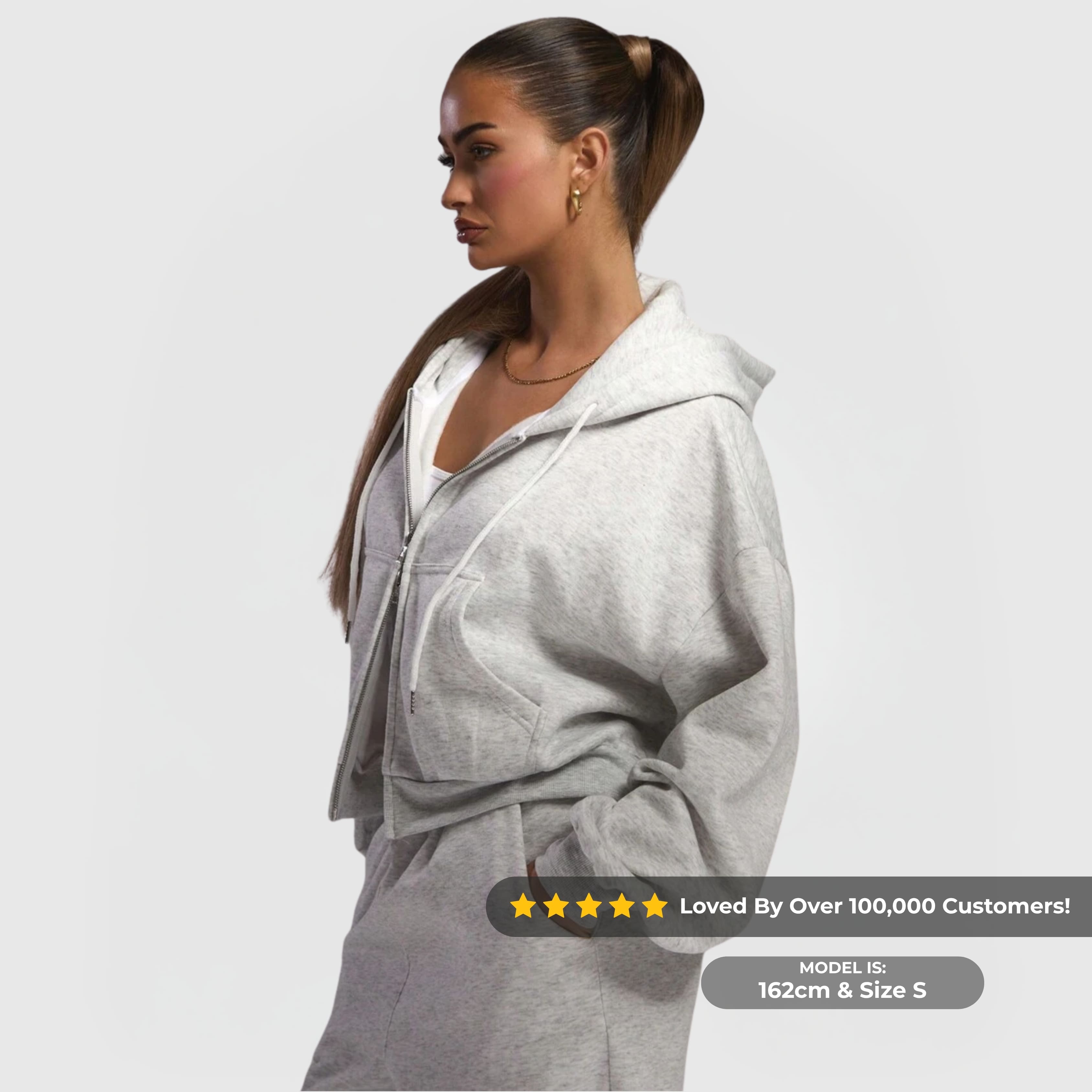 Woman wearing the Comfort Zip Hoodie – Grey with drawstring hood and full front zip in a relaxed pose.