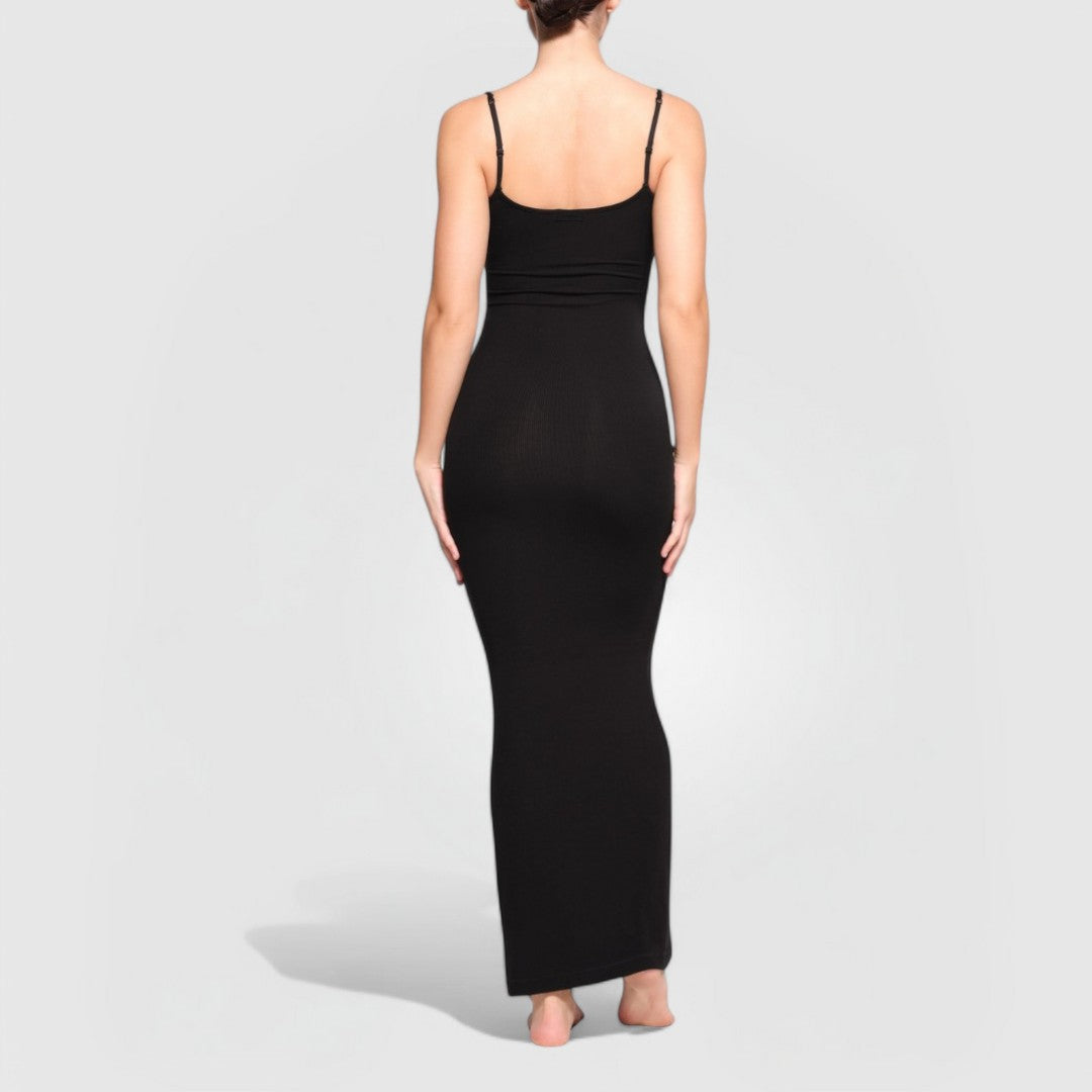 Woman wearing Sculpting Maxi Dress – Black in ribbed knit with thin straps and maxi length, shown from back.