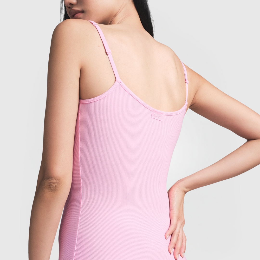 Back view of a woman wearing a pink Sculpting Maxi Dress with thin straps and ribbed texture.