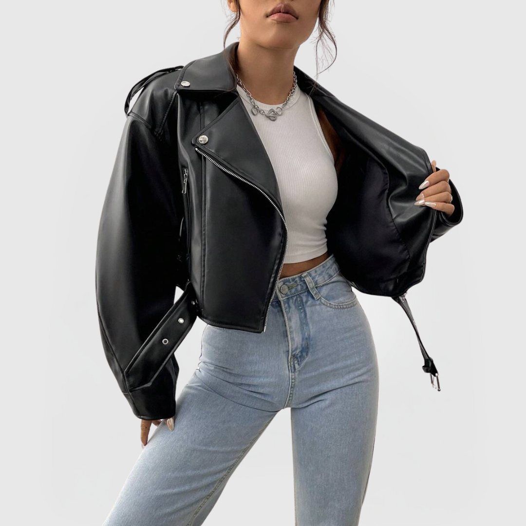 Woman wearing a black Cropped Biker Jacket with zipper front and adjustable toggle hem over white top and jeans
