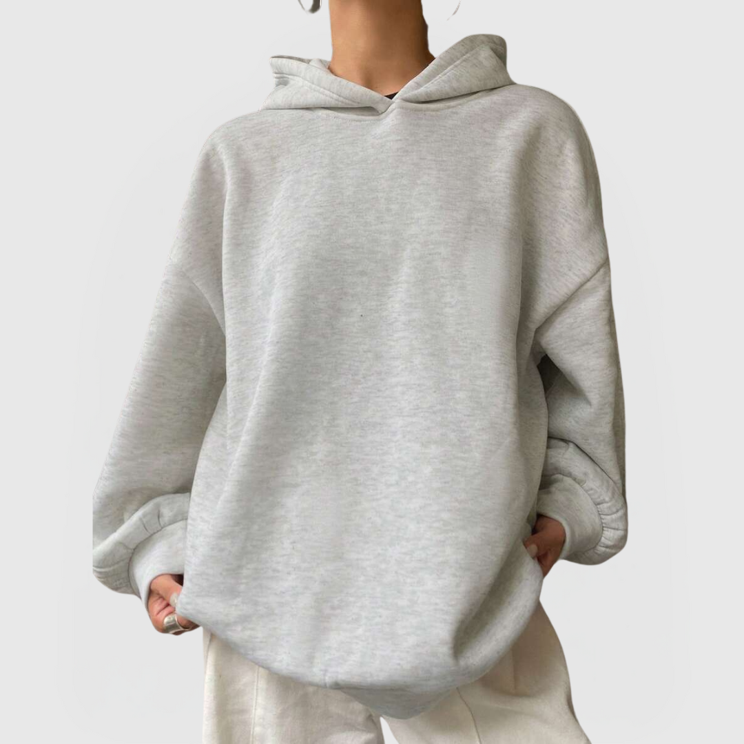 Model wearing an oversized grey hoodie with relaxed fit and dropped shoulders, Oversized Essential Hoodie – Grey.